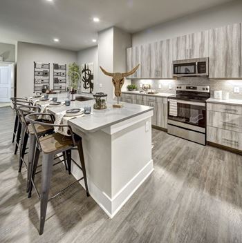 a kitchen with a large center island and a dining table at Arise Riverside, Texas, 78741